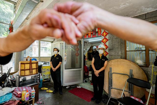 Officers from Hong Kong’s Lands Department, accompanied by police and other security personnel, enter resident Niki So’s village house during a land resumption operation in the Kwu Tung area of Hong Kong’s northern New Territories, on June 23, 2026. An area roughly a third of Hong Kong including villages, natural wetlands and farmland are being converted into the "Northern Metropolis", an ambitious project aimed at deepening integration with the mainland, diversifying the economy and providing new homes. (Photo by Leung Man Hei / AFP) / TO GO WITH AFP STORY: Hong Kong-economy-technology-development, FOCUS by Catherine LAI