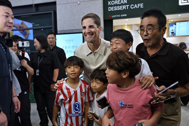 South Korea National Football Team’s interim coach Robert Moreno of Spain poses with football fans at Incheon International Airport on September 13, 2026. (Photo by Lillian SUWANRUMPHA / AFP)