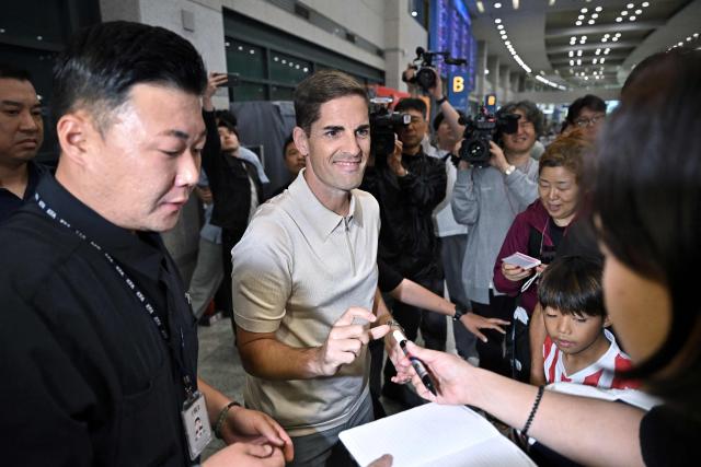 South Korea National Football Team’s interim coach Robert Moreno of Spain signs autographs at Incheon International Airport on September 13, 2026. (Photo by Lillian SUWANRUMPHA / AFP)
