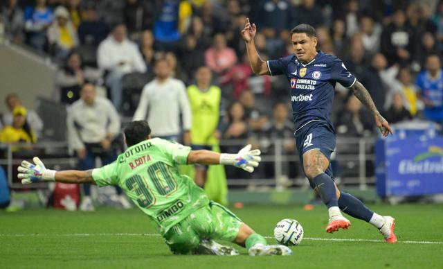 Cruz Azul's Uruguayan forward #21 Gabriel Fernandez evades America's goalkeeper #30 Rodolfo Cota to score his team's fourth goal during the Liga MX Apertura tournament football match between Cruz Azul and America, at the Banorte Stadium in Mexico City, on September 12, 2026. (Photo by Alfredo ESTRELLA / AFP)