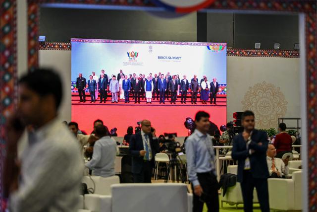 Mediapersons watch a digital screen showing leaders of participating countries gather for a family photograph during the 18th BRICS Summit in New Delhi on September 13, 2026. (Photo by Arun SANKAR / AFP)