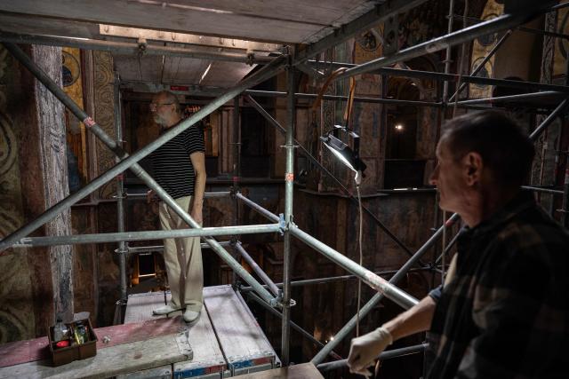 Anatoliy Ostapchuk (L), head of the Scientific Restoration Workshop of the National Reserve "Sophia of Kyiv", and Leonid Kolodnytskyi (R), restoration artist, conduct scheduled restoration works in the St. Sophia Cathedral in Kyiv on September 11, 2026, amid the Russian invasion of Ukraine. Despite the constant threat of missile and drone attacks, restorers have uncovered three compositions hidden from view for more than 70 years at Saint Sophia Cathedral, an architectural monument of Kyivan Rus. The former cathedral is one of the city's best known landmarks and the first heritage site in Ukraine to be inscribed on the World Heritage List. (Photo by Genya SAVILOV / AFP)