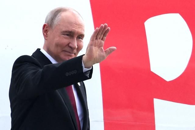 In this pool photograph distributed by the Russian state agency Sputnik, Russia's President Vladimir Putin waves as he embarks on a plane after attending the 18th BRICS Summit in New Delhi on September 13, 2026. (Photo by Alexander KAZAKOV / POOL / AFP) / ***Editor's note : this image is distributed by the Russian state owned agency Sputnik***