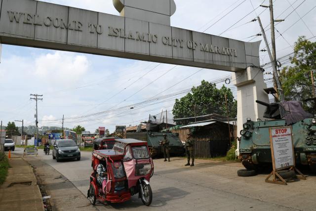 Motorists drive past an army check point with two M113 armored personnel carriers (APC) in Marawi City, Lanao del sur province, on the southern Philippines island of Mindanao on September 13, 2026, ahead of the first Bangsamoro Autonomous Region in Muslim Mindanao (BARMM) election. The Bangsamoro Autonomous Region in Muslim Mindanao, or BARMM, heads to its first-ever polls on September 14 - trading appointed parliamentarians for elected ones in the culmination of an on-off peace process that began in the late 1990s. (Photo by Ted ALJIBE / AFP)