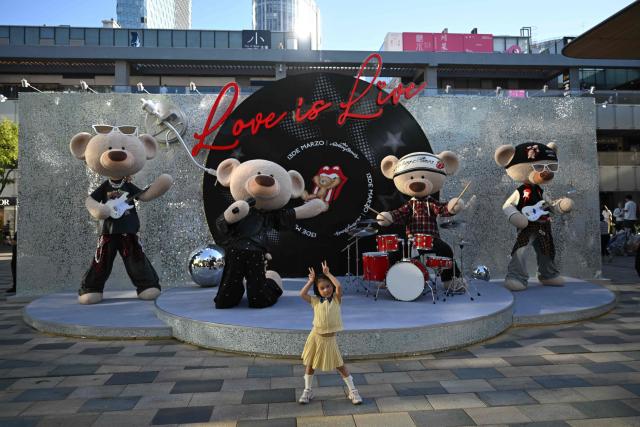 A girl poses for a picture in front of an 18 de Marzo store at a shopping mall in Beijing on September 13, 2026. (Photo by Pedro PARDO / AFP)