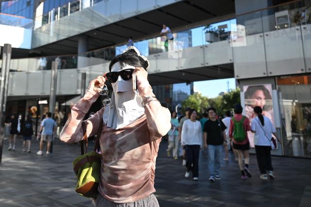 People visit a shopping mall in Beijing on September 13, 2026. (Photo by Pedro PARDO / AFP)