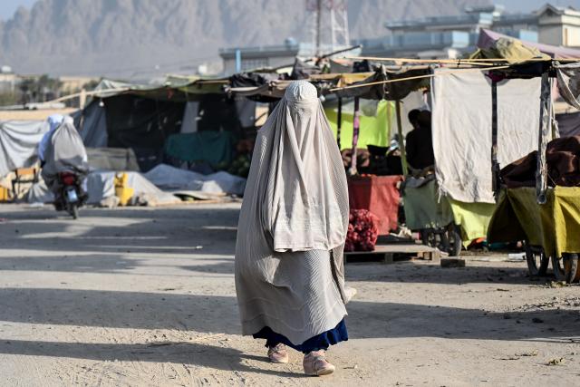 An Afghan burqa-clad woman walks along a street in Afghanistan's Kandahar province on September 13, 2026. (Photo by Sanaullah SEIAM / AFP)