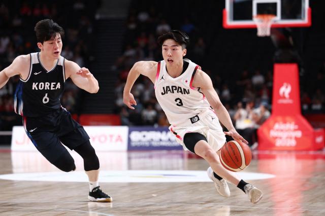 Japan's Kotetsu Kurokawa runs with the ball as he runs past South Korea's Lee Jung-hyun during their 2026 Asian Games men's group A basketball game at Aichi International Arena in Nagoya on September 13, 2026. (Photo by JIJI Press / AFP) / Japan OUT