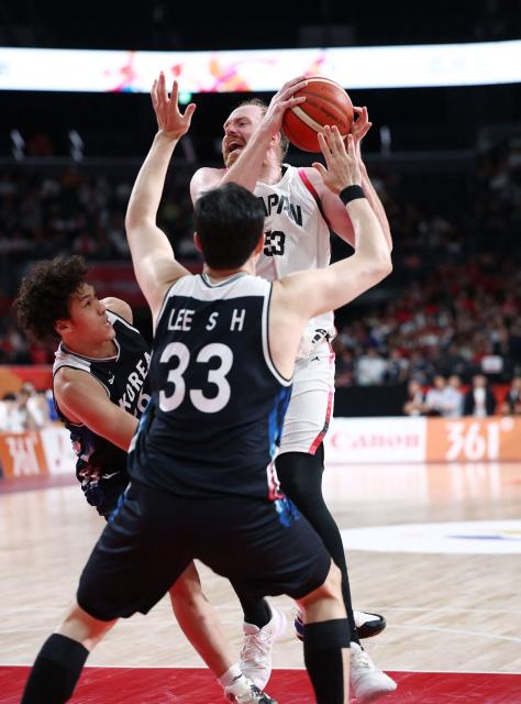 Japan's Alex Kirk is challenged by South Korea's Lee Seoung-hyun during their 2026 Asian Games men's group A basketball game at Aichi International Arena in Nagoya on September 13, 2026. (Photo by JIJI Press / AFP) / Japan OUT