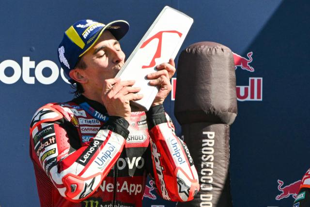 Ducati Lenovo Team's Spanish rider Marc Marquez kisses his trophy on the podium following his victory at the end of the San Marino Moto GP Grand Prix at the Misano World Circuit Marco Simoncelli, in Misano Adriatico, northern Italy on September 13, 2026. (Photo by Andreas SOLARO / AFP)