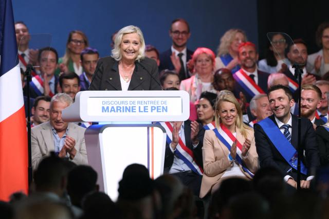 President of the far-right Rassemblement National (RN) parliamentary group and 2027 French presidential candidate Marine Le Pen (L) delivers a speech flanked by her campaign director Julien Sanchez (R) at a rally for the start of the new political year in Henin-Beaumont, northern France, on September 13, 2026. (Photo by Thomas SAMSON / AFP)