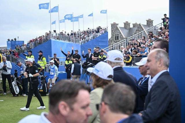 US President Donald Trump (2nd R-white cap) and Ireland's Prime Minister Michael Martin (R) watch Ireland's Shane Lowry (L) tees off, as they attend the final round of the Irish Open golf tournament at the Trump International Golf Links & Hotel, a resort and golf course owned by the president, in Doonbeg, western Ireland on September 13, 2026. Trump turned his focus on September 13 to golf and promoting his business interests, as he wraps up a two-day visit to Ireland during which his off-the-cuff diplomacy has caused another stir. (Photo by Brendan SMIALOWSKI / AFP)
