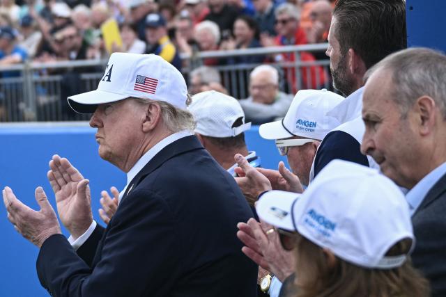 US President Donald Trump (L) and Ireland's Prime Minister Michael Martin (R) applaud as they attend the final round of the Irish Open golf tournament at the Trump International Golf Links & Hotel, a resort and golf course owned by the president, in Doonbeg, western Ireland on September 13, 2026. Trump turned his focus on September 13 to golf and promoting his business interests, as he wraps up a two-day visit to Ireland during which his off-the-cuff diplomacy has caused another stir. (Photo by Brendan SMIALOWSKI / AFP)