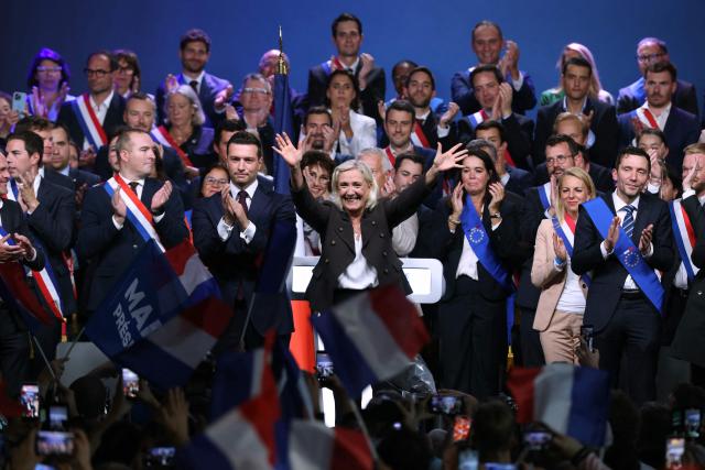 President of the far-right Rassemblement National (RN) parliamentary group and 2027 French presidential candidate Marine Le Pen (C) and RN President Jordan Bardella (C-L) react on stage at the end of a rally for the start of the new political year in Henin-Beaumont, northern France, on September 13, 2026. (Photo by Thomas SAMSON / AFP)