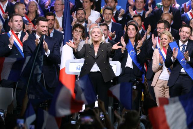 President of the far-right Rassemblement National (RN) parliamentary group and 2027 French presidential candidate Marine Le Pen (C) reacts flanked by RN President Jordan Bardella (2nd L) and her campaign director Julien Sanchez (R) react during a rally for the start of the new political year in Henin-Beaumont, northern France, on September 13, 2026. (Photo by Thomas SAMSON / AFP)