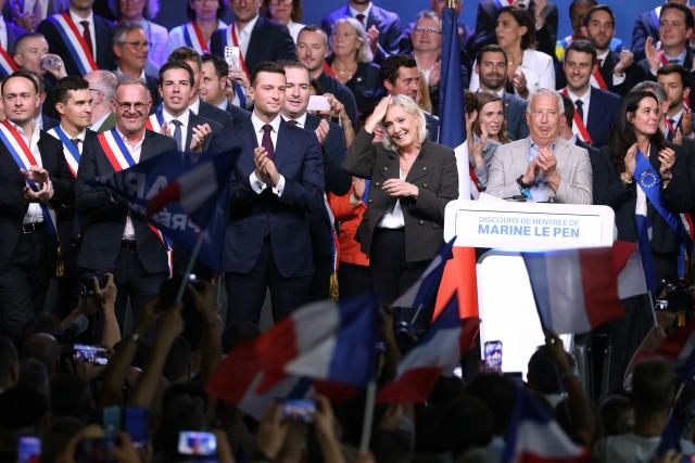 President of the far-right Rassemblement National (RN) parliamentary group and 2027 French presidential candidate Marine Le Pen (C) and RN President Jordan Bardella (C-L) and Mayor of Henin-Beaumont Steeve Briois (3rd L) react on stage at the end of a rally for the start of the new political year in Henin-Beaumont, northern France, on September 13, 2026. (Photo by Thomas SAMSON / AFP)