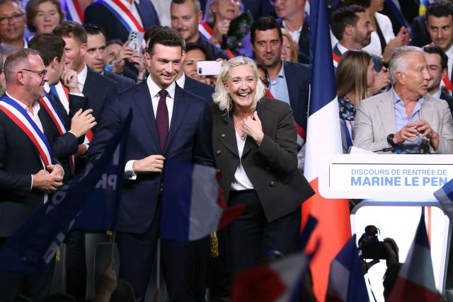 President of the far-right Rassemblement National (RN) parliamentary group and 2027 French presidential candidate Marine Le Pen (C) and RN President Jordan Bardella (2nd L) Mayor of Henin-Beaumont Steeve Briois (L) react on stage at the end of a rally for the start of the new political year in Henin-Beaumont, northern France, on September 13, 2026. (Photo by Thomas SAMSON / AFP)