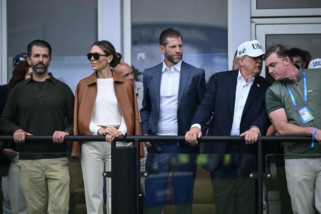 (L to R) Donald Trump Jr., his wife Bettina, Eric Trump and US President Donald Trump wait for the trophy presentation at the end of the Irish Open golf tournament at the Trump International Golf Links & Hotel in Doonbeg, western Ireland on September 13, 2026. (Photo by Brendan SMIALOWSKI / AFP)