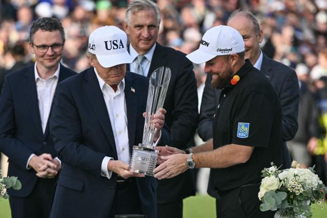 Ireland's Shane Lowry (R) and US President Donald Trump (2nd L) look at the trophy during the presentation following his victory on the final day of the Irish Open golf tournament at the Trump International Golf Links & Hotel, a resort and golf course owned by the president, in Doonbeg, western Ireland on September 13, 2026. (Photo by Brendan SMIALOWSKI / AFP)