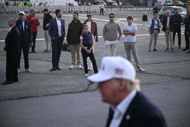 Members of US President Donald Trump's family wait as he (bottom) speaks to the media before boarding Air Force One to leave from Shannon Airport, western Ireland on September 13, 2026, after attending the final day of the Irish Open golf tournament in nearby Doonbeg. (Photo by Brendan SMIALOWSKI / AFP)