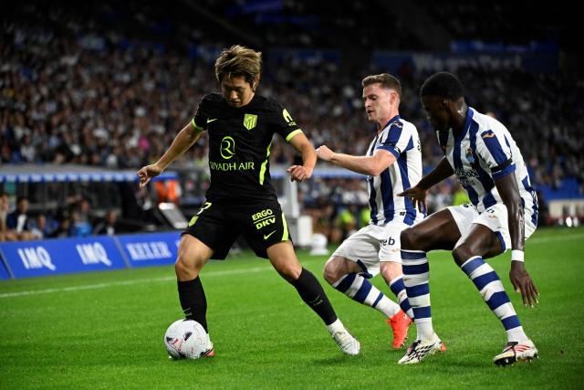 Atletico Madrid's South Korean midfielder #07 Kang-In Lee fights for the ball with Real Sociedad's Spanish forward #17 Sergio Gomez and Real Sociedad's French forward #19 Mamadou Sarr during the Spanish league football match between Real Sociedad and Club Atletico de Madrid at Anoeta Stadium in San Sebastian on September 13, 2026. (Photo by ANDER GILLENEA / AFP)
