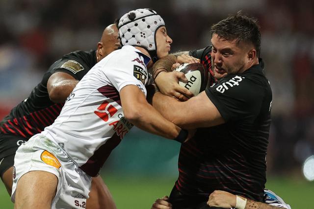 Toulouse's French prop Cyril Baille (R) is tackled by Bordeaux-Bègles' French wing Louis Bielle-Biarrey (C) during the French Top 14 rugby union match between Stade Toulousain and Bordeaux-Begles at the Stade Ernest-Wallon in Toulouse, southwestern France on September 13, 2026.  (Photo by Valentine CHAPUIS / AFP)