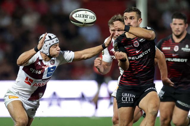 Toulouse's French full-back Thomas Ramos (R) passes the ball during the French Top 14 rugby union match between Stade Toulousain and Bordeaux-Begles at the Stade Ernest-Wallon in Toulouse, southwestern France on September 13, 2026.  (Photo by Valentine CHAPUIS / AFP)