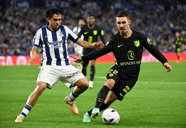 Real Sociedad's Venezuelan defender #02 Jon Aramburu fights for the ball with Atletico Madrid's Spanish defender #22 Alejandro Grimaldo during the Spanish league football match between Real Sociedad and Club Atletico de Madrid at Anoeta Stadium in San Sebastian on September 13, 2026. (Photo by ANDER GILLENEA / AFP)