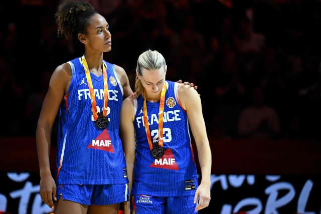 France's center #22 Marieme Badiane and France's shooting guard #23 Marine Johannes react with their silver medals after the 2026 FIBA Women’s Basketball World Cup final game between the United States and France in Berlin on September 13, 2026. (Photo by Tobias SCHWARZ / AFP)