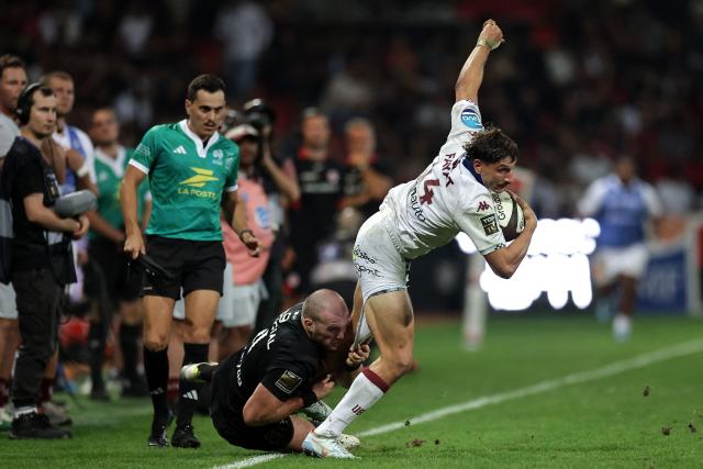 Bordeaux-Bègles' French wing Pablo Uberti (R) is tackled by Toulouse's Irish lock Joshua Brennan (C) during the French Top 14 rugby union match between Stade Toulousain and Bordeaux-Begles at the Stade Ernest-Wallon in Toulouse, southwestern France on September 13, 2026.  (Photo by Valentine CHAPUIS / AFP)