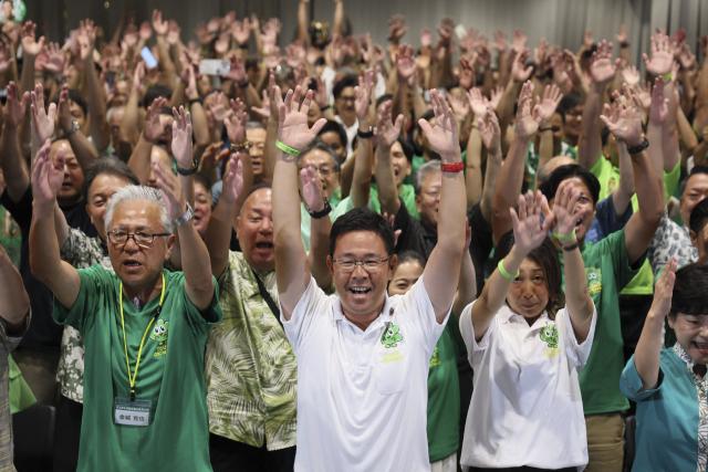 Genta Koja (front C) celebrates with his supporters after reports projected his victory in the Okinawa gubernatorial election in Naha, Okinawa prefecture on September 13, 2026. Koja won the September 13 gubernatorial election in Okinawa, Japan's southernmost prefecture, bringing into power a leader who approves a contentious US military base relocation plan for the first time in 12 years. (Photo by JIJI PRESS / AFP) / Japan OUT