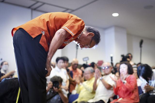 This picture taken on September 13, 2026 shows Denny Tamaki bowing to his supporters after reports projected his defeat in the Okinawa gubernatorial election, in Naha, Okinawa Prefecture. Tamaki, who was seeking his third term as governor of Okinawa, Japan's southernmost prefecture, lost to Genta Koja in the September 13 polls, bringing into power a leader who approves a contentious US military base relocation plan for the first time in 12 years. (Photo by JIJI PRESS / AFP) / Japan OUT