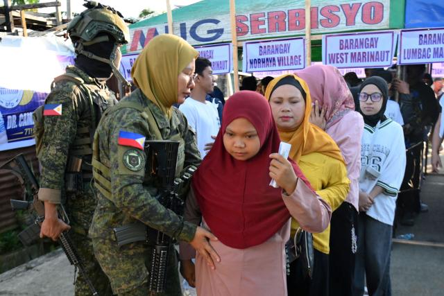 Voters are searched by soldiers before entering a polling station in Marawi City on the southern island of Mindanao on September 14, 2026, for the first elected parliament in the Bangsamoro Autonomous Region in Muslim Mindanao (BARMM) in the Philippines' far south. Voters across the Philippines' autonomous Muslim region began casting ballots for their first elected parliament on September 14, hours after gun violence left at least three people dead outside a polling station. (Photo by Ted ALJIBE / AFP)