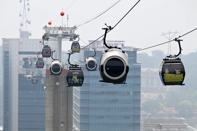 Cable cars travel to Sentosa island as haze shrouds Singapore on September 14, 2026. (Photo by Roslan RAHMAN / AFP)