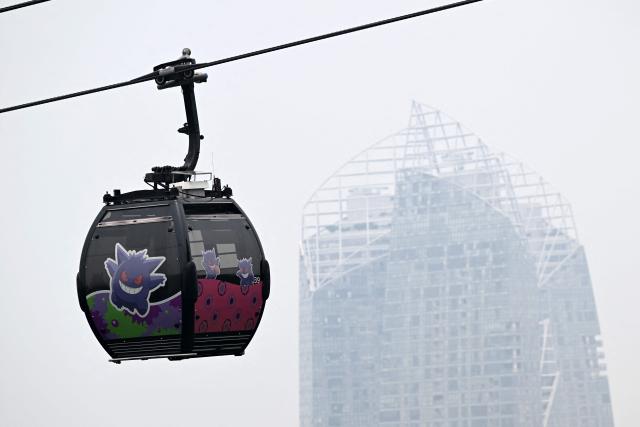 A cable car travels to Sentosa island as haze shrouds Singapore on September 14, 2026. (Photo by Roslan RAHMAN / AFP)
