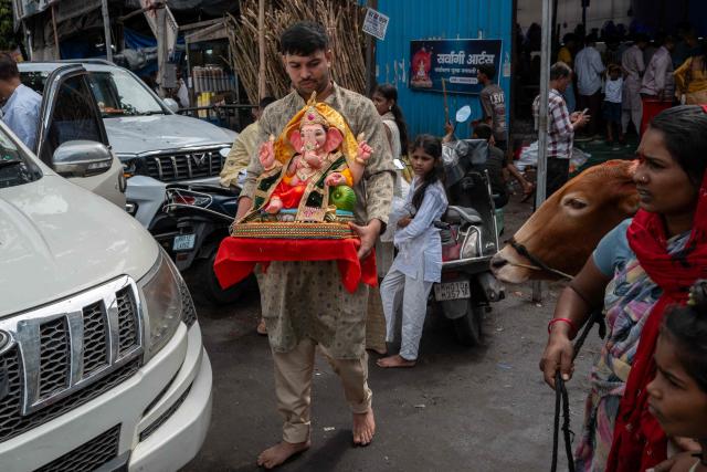 A devotee carries an idol of Hindu deity Ganesha on the occasion of ‘Ganesh Chaturthi’ festival in Mumbai on September 14, 2026. (Photo by Punit PARANJPE / AFP)