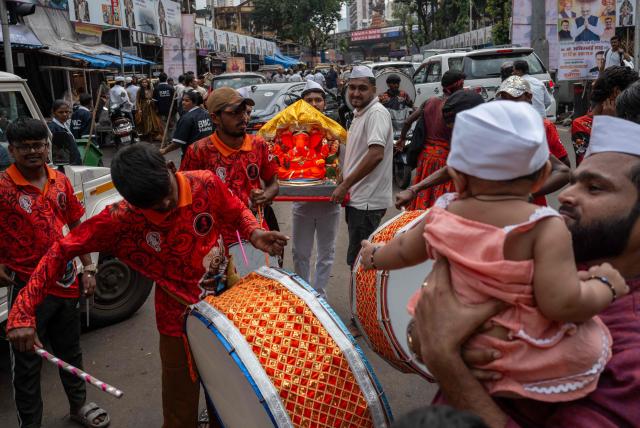 Devotees carry an idol of Hindu deity Ganesha, during a procession of the ‘Ganesh Chaturthi’ festival in Mumbai on September 14, 2026. (Photo by Punit PARANJPE / AFP)