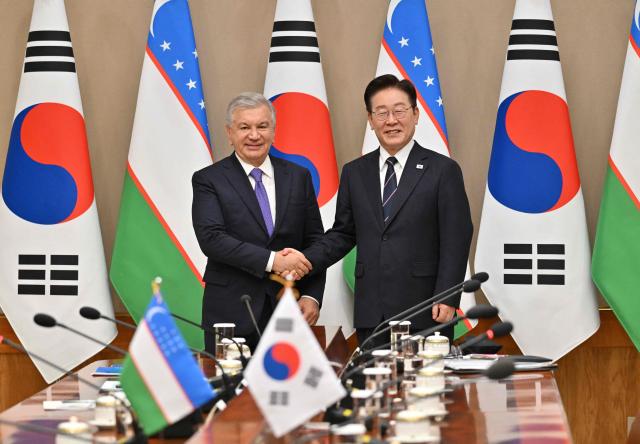 Uzbekistan's President Shavkat Mirziyoyev (L) shakes hands with South Korea's President Lee Jae Myung (R) during their meeting at the presidential Blue House in Seoul on September 14, 2026, on the sidelines of the 1st Korea-Central Asia Summit. (Photo by JUNG YEON-JE / POOL / AFP)