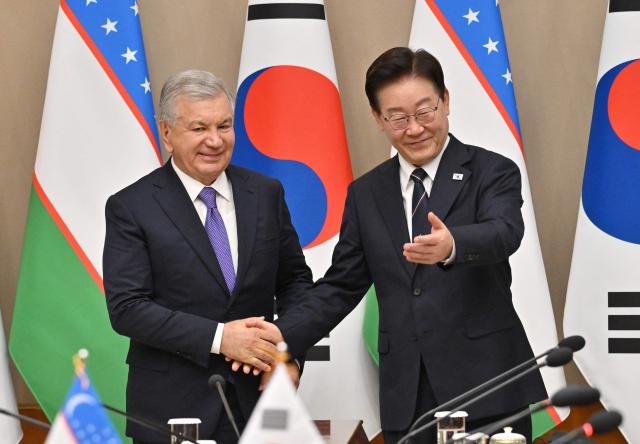 Uzbekistan's President Shavkat Mirziyoyev (L) shakes hands with South Korea's President Lee Jae Myung (R) during their meeting at the presidential Blue House in Seoul on September 14, 2026, on the sidelines of the 1st Korea-Central Asia Summit. (Photo by JUNG YEON-JE / POOL / AFP)