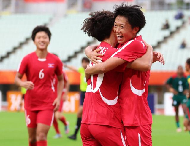 North Korea's Ri Song-a (R) celebrates after a goal during the 2026 Asian Games women's group B football match against Bangladesh at Yanmar Stadium Nagai in Osaka on September 14, 2026. North Korea's formidable women's football team launched their Asian Games with a 10-0 hammering of Bangladesh, cheered on by several hundred pro-Pyongyang fans in Osaka. (Photo by JIJI Press / AFP) / Japan OUT