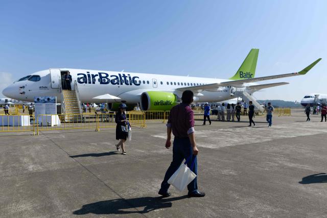 (FILES) This photograph taken at Airshow China 2018 in Zhuhai in southern China's Guangdong province on November 7, 2018 shows visitors looking at an Airbus A220-300 air Baltic passenger plane. Latvia's AirBaltic said on September 14, 2026 that it had filed for protection under Chapter 11 of the US Bankruptcy Code, as it tries to reduce its debt amid increased fuel prices brought on by the Iran war. (Photo by WANG Zhao / AFP)