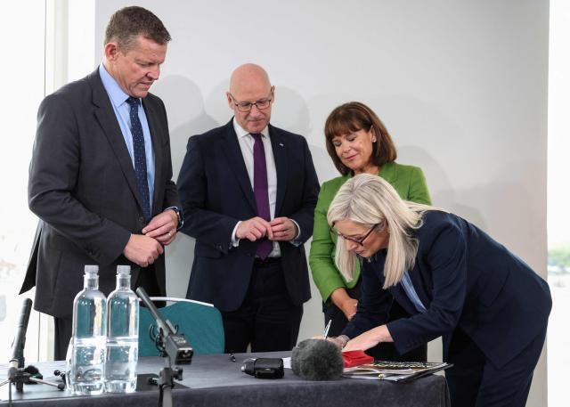 Rhun ap Iorwerth (L) of Plaid Cymru in Wales, Scottish Nationalist Party (SNP) leader John Swinney (2nd L) and Mary Lou McDonald (2nd R), president of Irish Republicans Sinn Fein look on as Michelle O'Neill (R), vice president of Irish Republicans Sinn Fein signs a memorandum of understanding as they attend a meeting in Cardiff, Wales on September 14, 2026, to press for self-determination votes in their territories. The leaders of the main Scottish, Northern Irish and Welsh parties on September 14 declared their right to "self determination" in a joint agreement signed at a rare meeting in the Welsh capital Cardiff. (Photo by Adrian DENNIS / AFP)