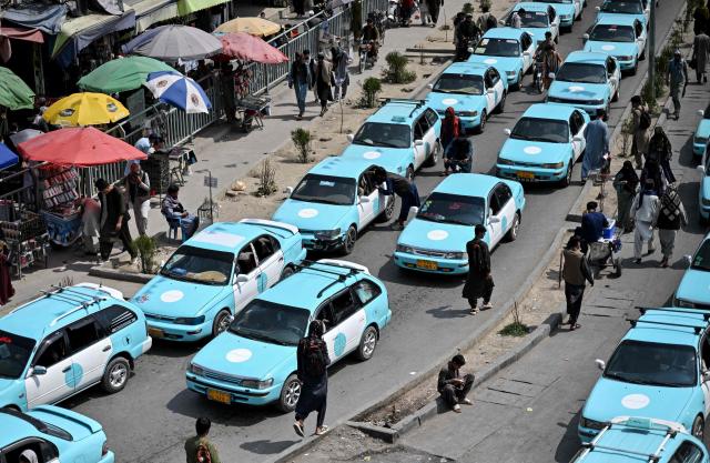 Commuters riding blue taxis wait in a traffic jam in Kabul on September 14, 2026. (Photo by Wakil KOHSAR / AFP)
