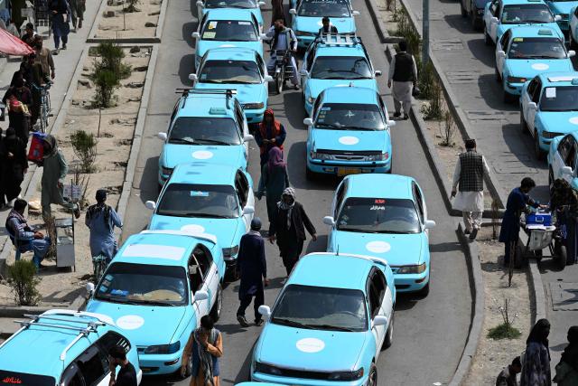 Commuters riding blue taxis wait in a traffic jam in Kabul on September 14, 2026. (Photo by Wakil KOHSAR / AFP)