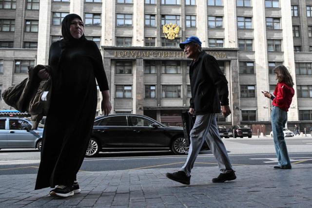 People walk past the Russian State Duma (lower house of Russia's Parliament) in central Moscow on September 14, 2026. The 2026 parliamentary election will be held over a three-day period from September 18 to 20. (Photo by Igor IVANKO / AFP)