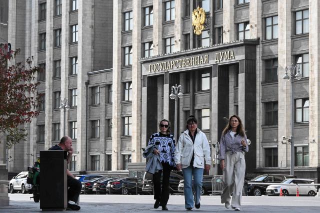 People walk along the street in front of the Russian State Duma (lower house of Russia's Parliament) in central Moscow on September 14, 2026. The 2026 parliamentary election will be held over a three-day period from September 18 to 20. (Photo by Igor IVANKO / AFP)