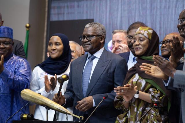 Aliko Dangote (C) the President and Chief Executive Officer of the Dangote Group, hits the gong during the Dangote Refinery's inital public offering (IPO) at the Nigerian Exchange Group in Lagos, NIgeria on September 14, 2026. Nigerian billionaire Aliko Dangote on Monday launched what is slated as Africa's biggest initial public offering, which aims to raise $1.6 billion from his mega oil refinery.
Describing it as an "historic day", Dangote said in a statement that the IPO was "not simply about listing a company. It is about listing a new possibility for Nigeria, and for Africa". (Photo by Temiloluwa Johnson / AFP)