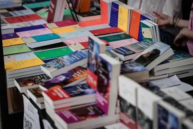 (FILES) Books are displayed at the Paris Book Fair at the Grand Palais in Paris on April 17, 2026. Despite falling readership, they remain convinced of the future of books: new publishing houses are being launched with the ambition of remaining independent from major groups and broadening the range of titles available to readers. (Photo by STEPHANE DE SAKUTIN / AFP)