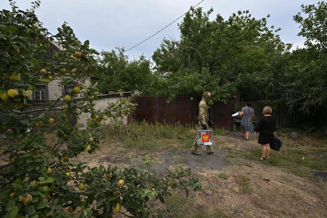 Members of a local election commission, accompanied by a Russian serviceman, visit voters at home during early voting in Russia's parliamentary election in the settlement of Verbovka in the Donetsk region, Russian-controlled Ukraine, on September 14, 2026, amid the ongoing Russian-Ukrainian conflict. The 2026 parliamentary election will be held over a three-day period from September 18 to 20. (Photo by AFP)