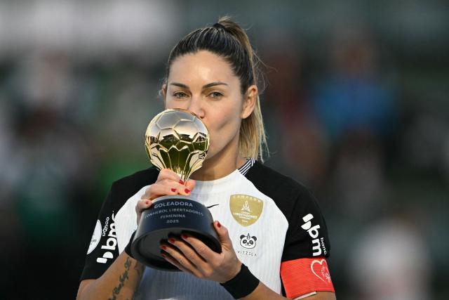 (FILES) Corinthians' midfielder #10 Gabi Zanotti kisses her 2025 Women's Copa Libertadores top scorer trophy at the podium following the final football match between Colombia's Deportivo Cali and Brazil's Corinthians, at the Florencio Sola stadium in Banfield, Buenos Aires province on October 18, 2025. Brazil's Corinthians, the dominant force in South American women's football, tops the "group of death" in the 2026 Copa Libertadores, which will be held in Quito in October, according to the draw held in Paraguay on September 14. (Photo by Luis ROBAYO / AFP)